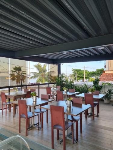 a restaurant with tables and chairs and a balcony at Verde Mar Pousada in João Pessoa