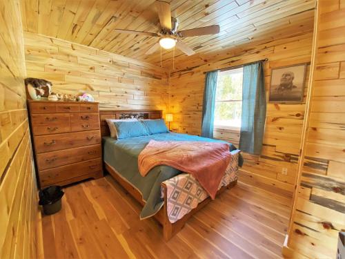 a bedroom with a bed in a log cabin at The Red Pine in Saint Ignace