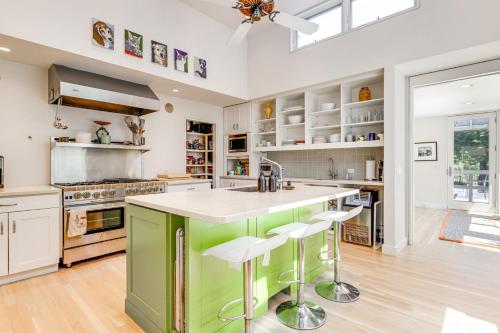 eine Küche mit einer grünen Insel mit Barhockern in der Unterkunft Pathside Cove by Rove Travel - 4BR Villa with Outdoor Spaces in Wainscott