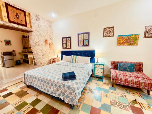 a bedroom with a blue bed and a chair at Casa Chaak Maya - Estudio privado con alberca en Mérida in Mérida