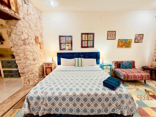 a bedroom with a blue bed and a chair at Casa Chaak Maya - Estudio privado con alberca en Mérida in Mérida