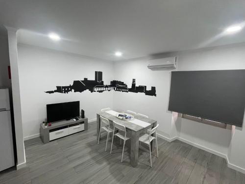 a living room with a table and a flat screen tv at Casa do Ferrador in Moura