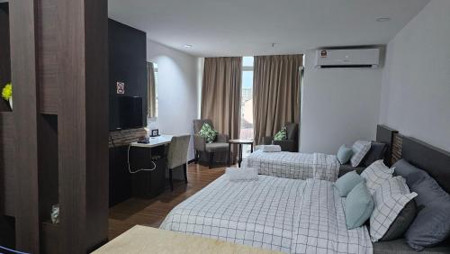a hotel room with two beds and a couch at KITA Studio - Kota Bharu City Point in Kota Bharu