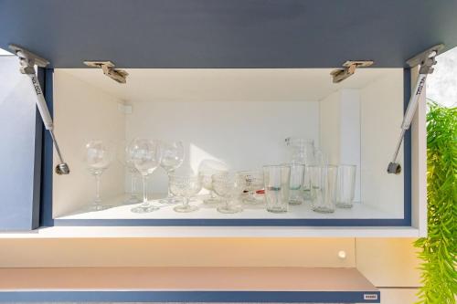 a shelf with wine glasses in a cabinet at Studio Completo para 3 pessoas com A/C - EIX0302 in Curitiba