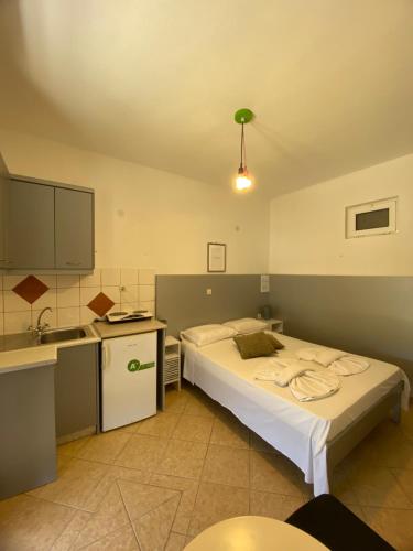 a bedroom with a bed and a kitchen with a sink at Pansion Limni in Keri