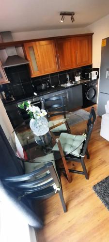a kitchen with a glass table and chairs in it at Palace flat in London
