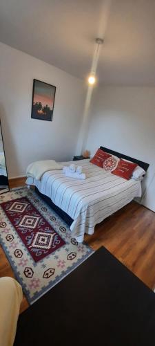 a bedroom with two beds and a rug on the floor at Palace flat in London