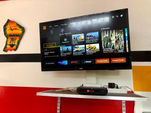 a flat screen tv hanging on a wall at Studio king-size bed, all comfort in Balaté in Saint-Laurent du Maroni