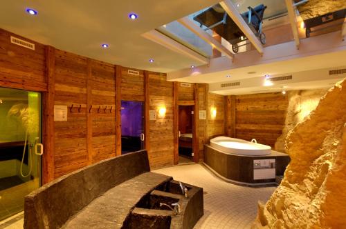 a bathroom with a tub and a sink in it at Saaserhof Apartments in Saas-Fee