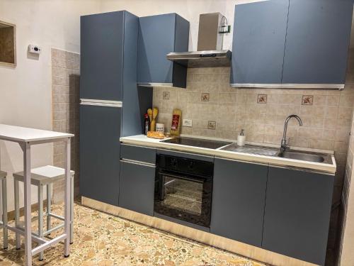 a kitchen with blue cabinets and a sink and an oven at Il fico d'india in Marsala