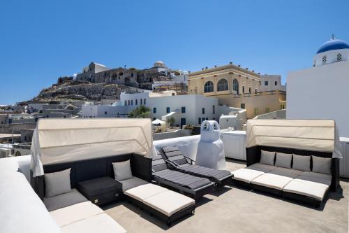 a patio with two chairs and tables on a roof at Historical Villa Santa Croce in Pirgos