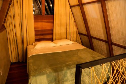 a small bed in a room with a window at Chalés Mont Hermon in Castro