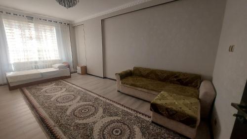 a living room with a couch and a rug at Квартира 2 х комнатная in Dushanbe