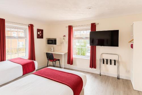 a hotel room with two beds and a flat screen tv at The Railway Sleeper Lodge in Colchester