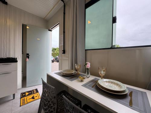 TijucasAconchego Urbano em Tijucas n 06的餐桌,上面有盘子和玻璃杯