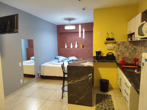 a kitchen with a counter and a bed in a room at Pousada Confort in Sao Paulo