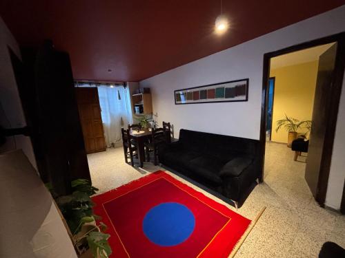a living room with a red and blue rug on the floor at Departamento en el centro de Oaxaca in Oaxaca City