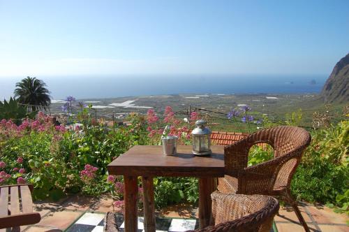 a wooden table and chairs with a view of the ocean at El Sitio in Frontera