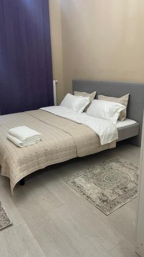 a large bed with white sheets and pillows on it at Евро двушка in Astana