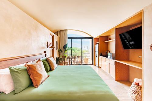 una camera da letto con un letto con una grande finestra di Studios with Plunge Pool near the Beach a Playa del Carmen