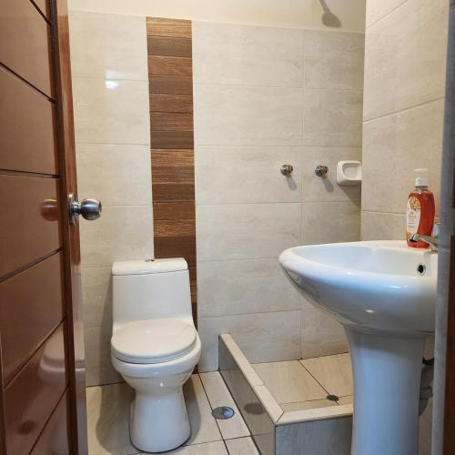 une salle de bains avec toilettes et lavabo dans l'établissement chiclayo, à La Victoria