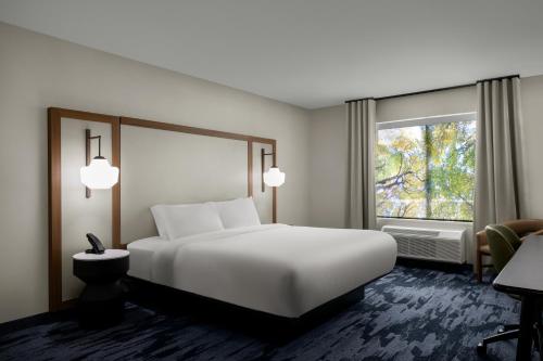 a bedroom with a large white bed and a window at Fairfield by Marriott Inn & Suites Beckley in Beckley