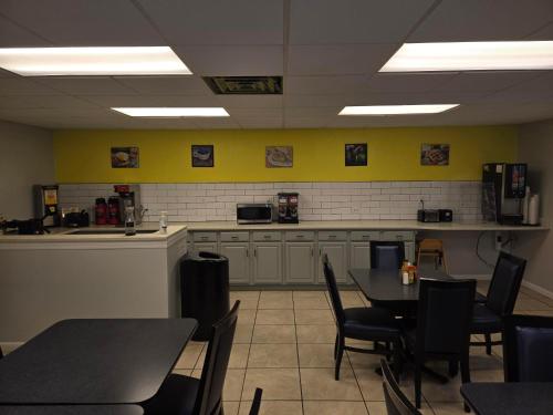 湖城湖城速8酒店的一间有桌椅和厨房的餐厅