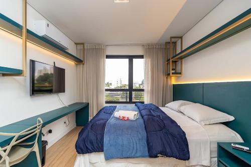 a bedroom with a large bed and a window at Studio Completo em Região Tranquila - EIX0502 in Curitiba