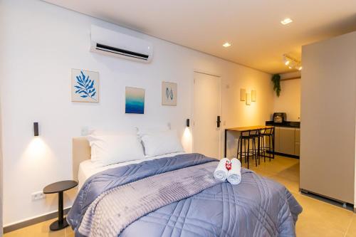 a bedroom with a bed with a pair of shoes on it at Estúdio Completo Com Vaga - EIX0506 in Curitiba