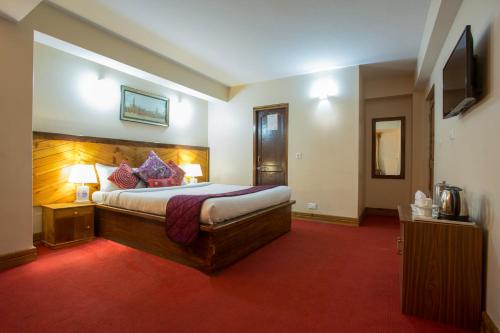 a hotel room with a bed and a television at Hotel Golden Sunrise & Spa in Pelling