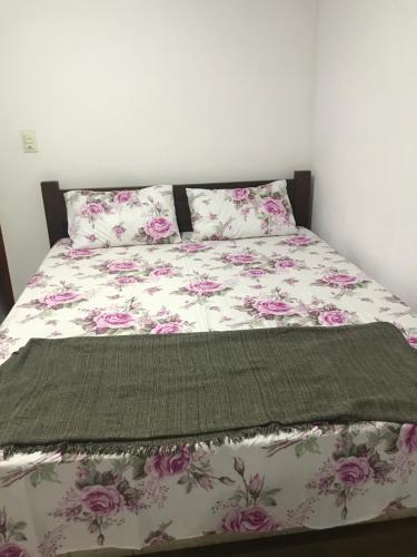 - une chambre avec un lit orné de fleurs roses dans l'établissement casa Hamburgo, à Búzios