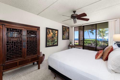 a bedroom with a bed and a ceiling fan at Kona Pacific E630 in Kailua-Kona