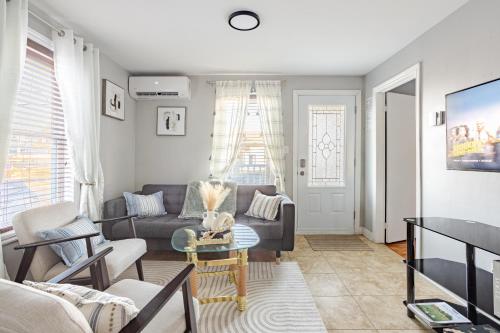 a living room with a couch and a table at Grande maison moderne 4 chambres - Spa Jaccuzi, Jardin & Parking gratuit - Idéale Familles et groupes in Saint-Jean-sur-Richelieu