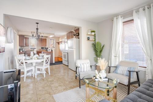 a living room with a table and a kitchen at Grande maison moderne 4 chambres - Spa Jaccuzi, Jardin & Parking gratuit - Idéale Familles et groupes in Saint-Jean-sur-Richelieu