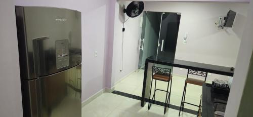 a kitchen with a black counter and a refrigerator at Loft 2 Hospede-se em Frente ao Parque ecológico in Indaiatuba