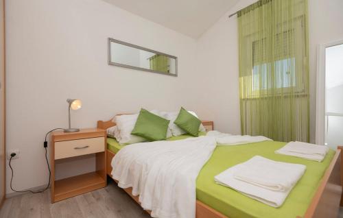 a bedroom with a bed with green sheets and a night stand at House Dragica in Nenadići