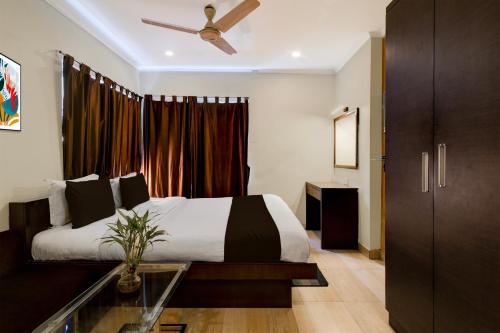 a bedroom with a bed and a ceiling fan at Super Townhouse New Digha Formerly Hotel Coral in New Digha