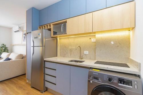 a kitchen with a washer and a sink and a refrigerator at Estúdio Completo para 5 Pessoas Com Vaga - EIX0703 in Curitiba