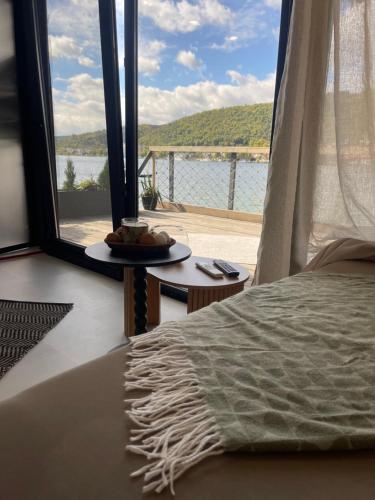 a bedroom with a bed and a view of the water at ISH Danube Village in Orşova