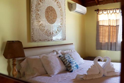 a bedroom with two swans sitting on a bed at Wallac Bungalows Canoas de Punta Sal in Canoas De Punta Sal