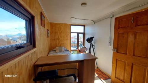 a room with a wooden desk and a window at CABAÑA EL BUHO - ESMERALDA in Puerto Natales