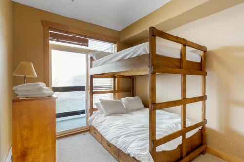 a bedroom with a bunk bed and a window at Glacier Lodge 106 in Big White