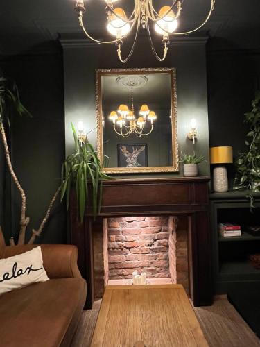 a living room with a fireplace and a mirror at Victorian Inspired Home in Stockport