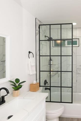 a bathroom with a toilet and a glass shower at Massive Backyard - Pool, Hot Tub, Putting Green, & Fire Pit in Tempe