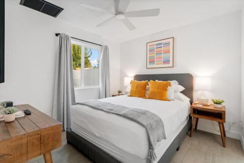 Un dormitorio con una cama con almohadas amarillas y una ventana. en 4BR 3BA Tempe Home with Pool, Hot Tub, Putting Green, & Game Room, en Tempe Junction