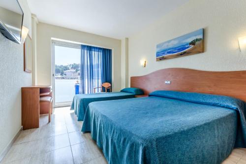 um quarto de hotel com duas camas e uma janela em Hotel Mar Blau em Calella