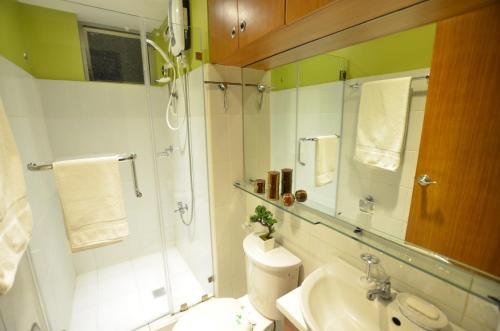 a bathroom with a shower and a toilet and a sink at A Homey Place At Adriatico in Manila