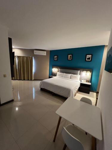 a bedroom with a bed and a blue wall at Hotel El Rancho in Sabinas Hidalgo