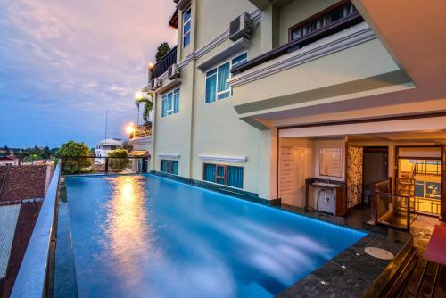 a swimming pool in the backyard of a house at Seng Hout Hotel in Battambang