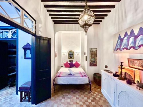 a bedroom with a bed with pink pillows at Tangier Heritage Riad - Bay Views & Kasbah in Tangier